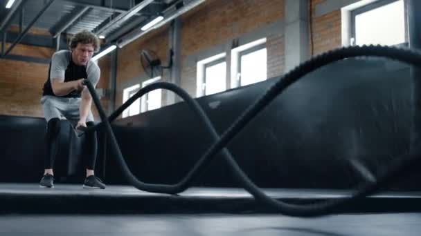 Aggressiver Kickboxer beim Workout im Fitnessstudio. Sportler mit Kampfleinen - Filmmaterial, Video