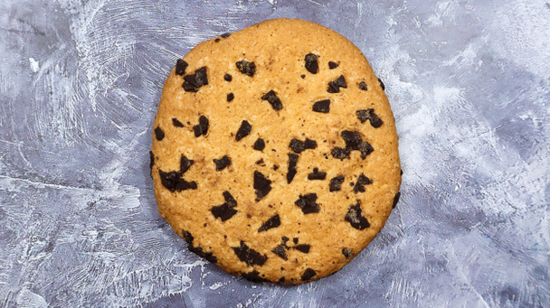 灰色の大理石のキッチンカウンターの上に、柔らかく焼きたてのチョコレートチップクッキーがあります。アメリカの伝統菓子デザート。おいしい甘い食べ物。平敷. - 写真・画像