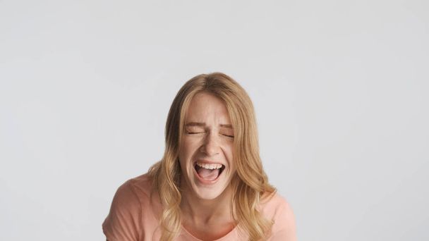 Portrait of emotional blond girl screaming on camera isolated on white background - Photo, Image