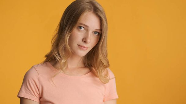 Beautiful shy blond girl posing on camera isolated on colorful background. Copy space for text or advertising content - Fotografie, Obrázek