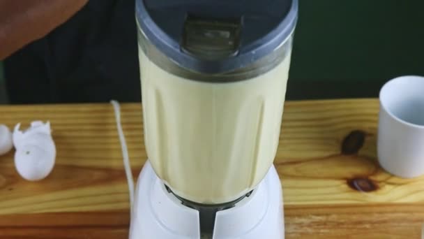 πάνω όψη στο ηλεκτρικό μπλέντερ ανάμειξη γάλακτος, συμπυκνωμένου γάλακτος και αυγών - Πλάνα, βίντεο