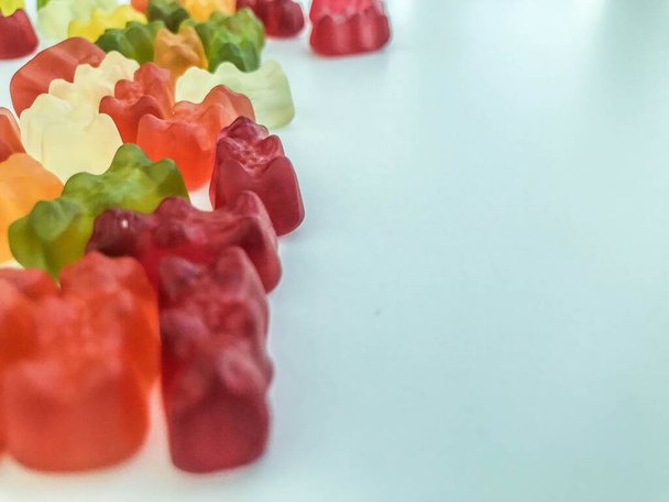 voluminous, bright gelatinous gummy bears. bears lie on a matte background. volumetric figure. bears of heterogeneous different structure. delicious and mouth-watering creative dessert - Foto, immagini