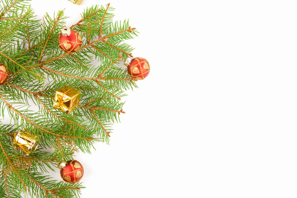Fondo navideño, ramas naturales de abeto con adornos rojos y regalos dorados aislados en banner web de año nuevo blanco y horizontal - Foto, Imagen