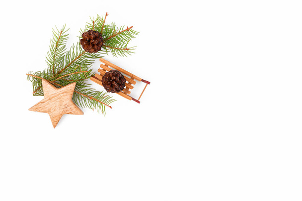 Karácsonyi háttér keret fenyő ágak, fa nulla hulladék otthoni dekoráció: szán, csillagok és karácsonyfa fehér háttér, felülnézet. Újrahasznosítható fenntartható újrahasznosított dekoráció. Környezetbarát új év - Fotó, kép