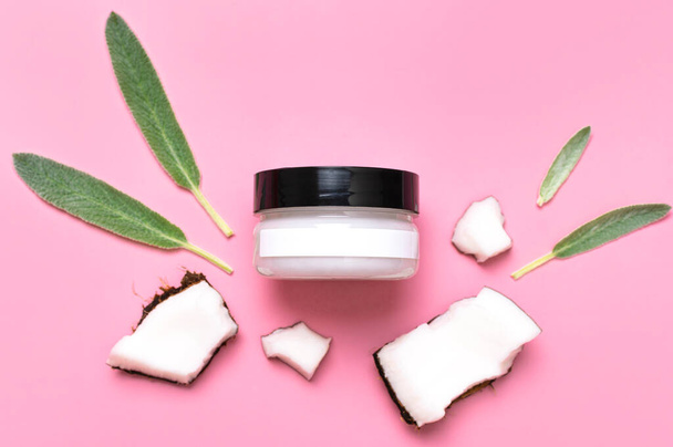 Natural organic eco cosmetics with coconut oil. Cosmetic containers with cream and lotion, broken coconut, green leaves on pink background flat lay top view. Beauty SPA branding mock-up. Blank label. - Photo, Image