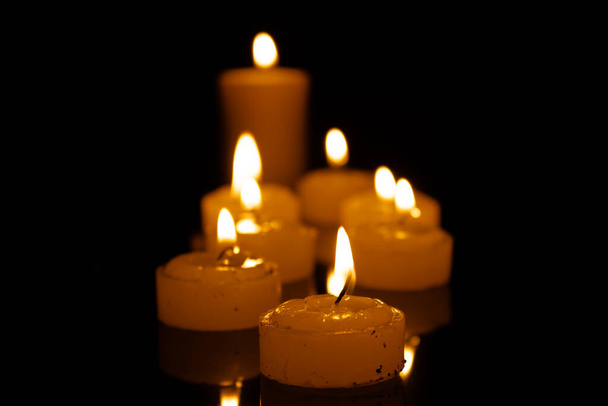Kerzen brennen in der Nacht. Selektiver Fokus. dunkler Hintergrund - Foto, Bild