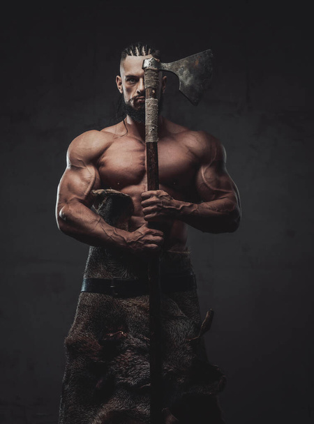 Nord guerrero posando con su hacha en el fondo oscuro - Foto, imagen