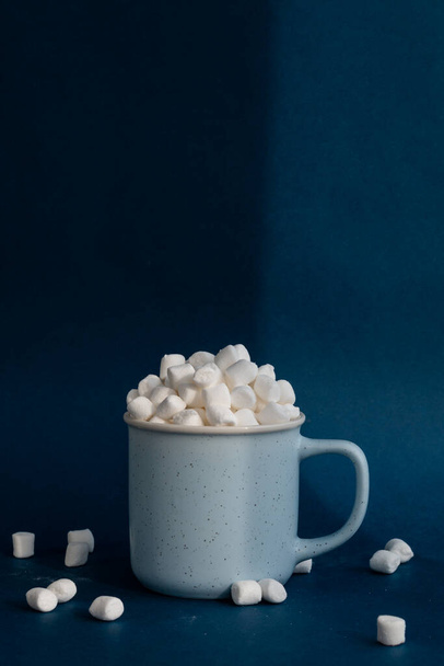 marshmallows em uma xícara contra fundo azul escuro - Foto, Imagem
