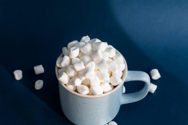 marshmallows in a cup against dark blue background - Фото, зображення