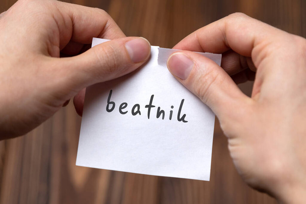 Mãos arrancando papel com a inscrição beatnik - Foto, Imagem