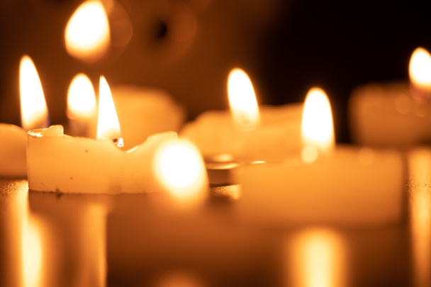 Close up de velas em chamas na mesa de madeira com fundo de velas de Natal borradas - Foto, Imagem