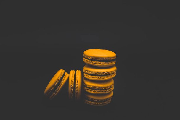 Colored macaroons. Sweet dessert cake for the whole family on a black matte background - Foto, imagen