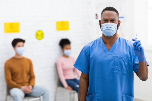 Black Doctor In Face Mask Holding Syringe Standing In Hospital - Foto, immagini