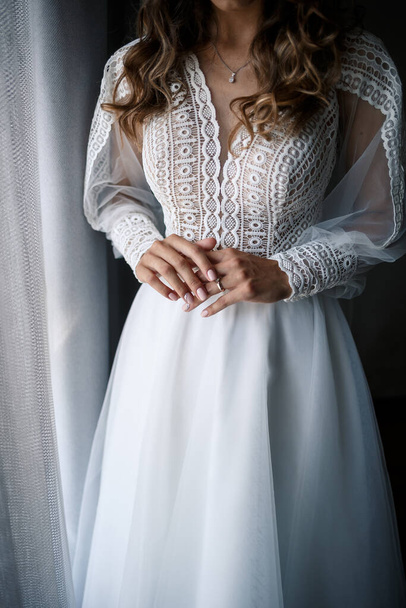 A menyasszony gyengéd női kezei, arany jegygyűrűvel a gyűrűsujján. - Fotó, kép