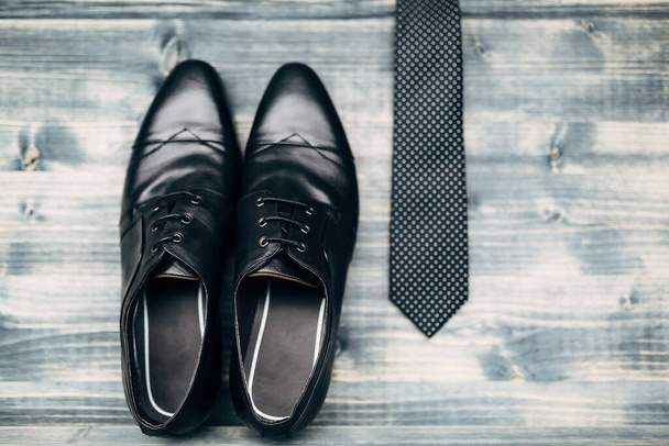 Homens sapatos de couro preto com um laço preto com bolinhas brancas pontos em uma textura de madeira cinza. - Foto, Imagem