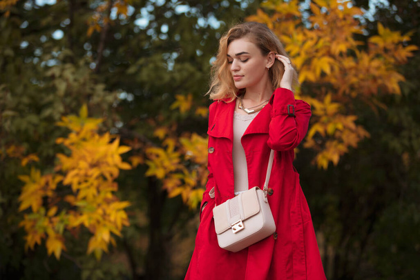 Portrait of woman in red coat at autumn tree yellow leaves - Fotografie, Obrázek