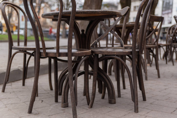 wooden tables with chairs of a street cafe without visitors, time of pandemic, quarantine, restrictions - Valokuva, kuva