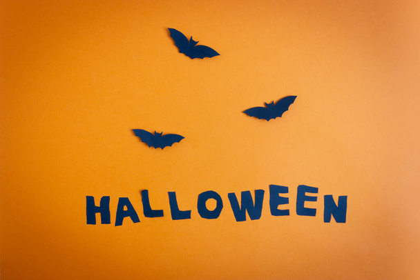 Halloween paper bats and word halloween on the orange background. - Fotografie, Obrázek