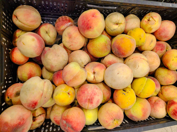 Juicy peaches are on the counter in a vegetable store - Фото, изображение