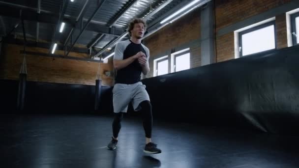 De jonge kickbokser doet lunges in de sportschool. Sportman maken van oefeningen in sportclub - Video