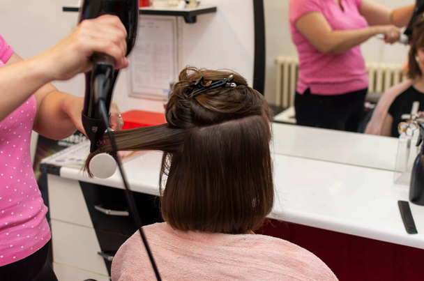 Hermosa chica adolescente en la peluquería golpe secando su pelo corto - Foto, imagen