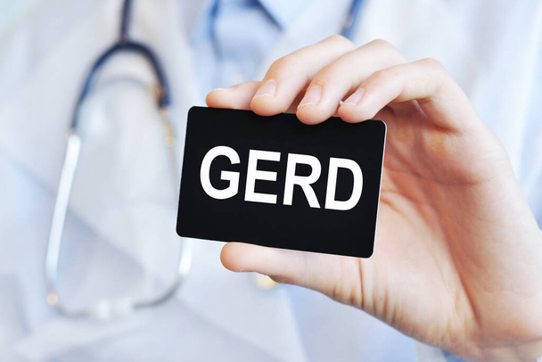 Lekarz trzymający czarną kartkę z tekstem GERD, koncepcja medyczna - Zdjęcie, obraz