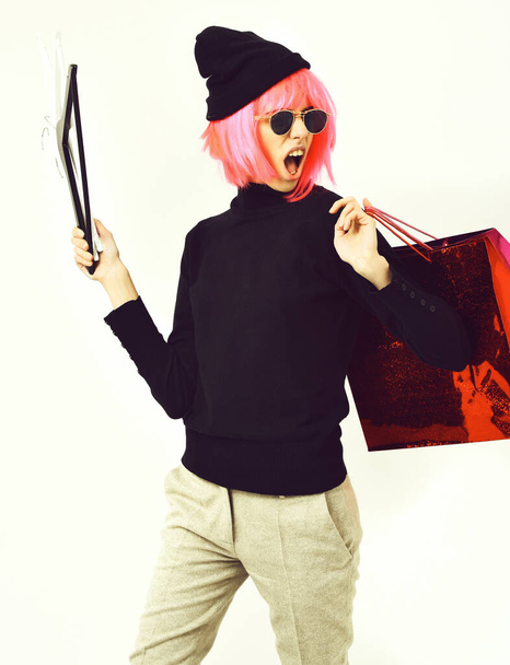 menina sexy na moda em rosa peruca segurando pacote com cabides - Foto, Imagem