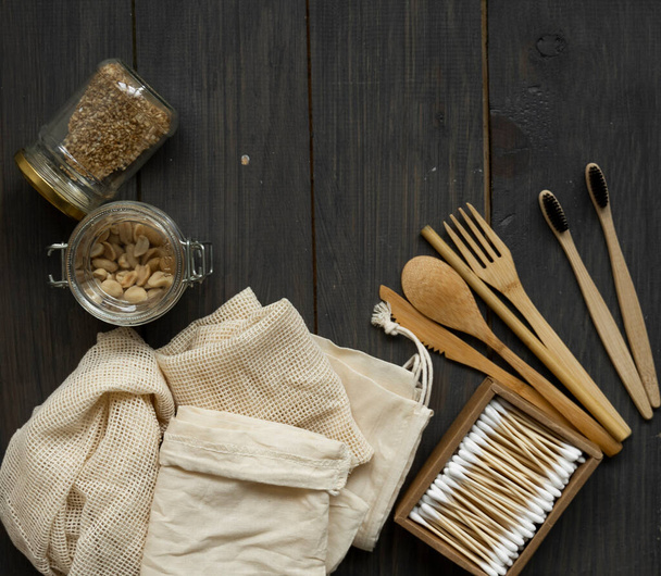 Zero waste kit. Set of eco friendly bamboo cutlery and cleaning brushes, mesh cotton bags, glass jars, loofah, bamboo toothbrushes and box of cotton swabs. Natural and reusable items accessories. - Photo, image