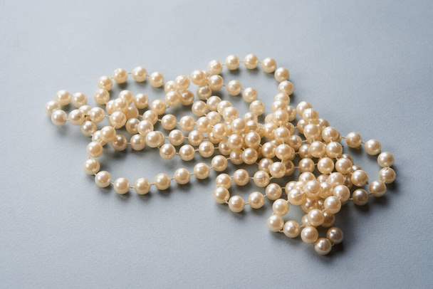 Pearl beads on a gray background decoration decoration top view - Foto, afbeelding