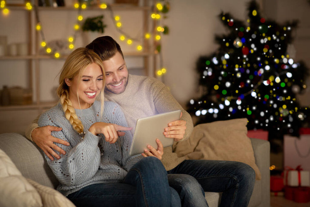 Радісна пара грає разом вдома на цифровому планшеті
 - Фото, зображення