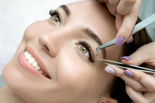 Eyelash Extension Procedure.  Beauty Model with  Perfect Fresh Skin and Long Eyelashes. Slincare, Spa and Wellness. Make up,  Hair and Lashes. Close up. - Valokuva, kuva