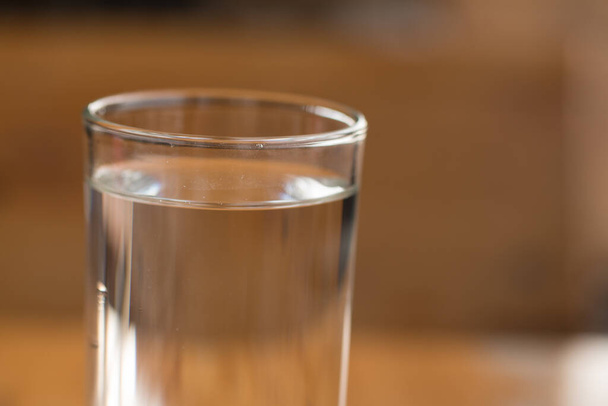Ποτήρι νερό σε ξύλινο γραφείο. - Φωτογραφία, εικόνα