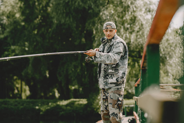 Άνδρας που ψαρεύει και κρατά το καλάμι - Φωτογραφία, εικόνα