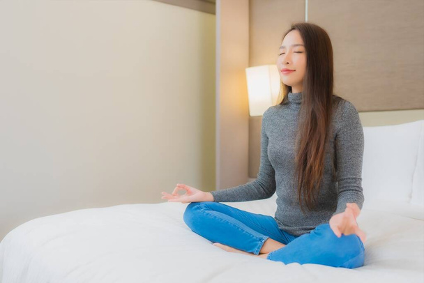 Portrait beautiful young asian woman meditation on bed in bedroom interior - Photo, Image