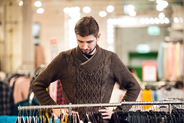 A handsome young man shopping at a clothing store - Fotó, kép