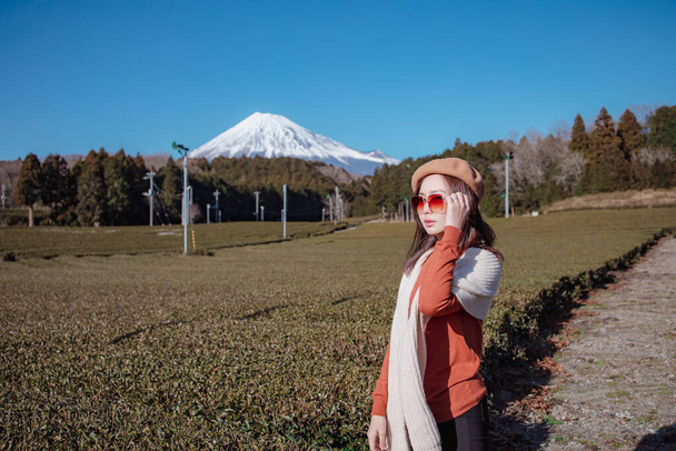 Mujer bonita de pie en medio del árbol de té con vista a Fuji Mountian en Fujinomiya, Shizuoka. Shizuoka es uno de los mejores naturales del té en el mundo. - Foto, Imagen