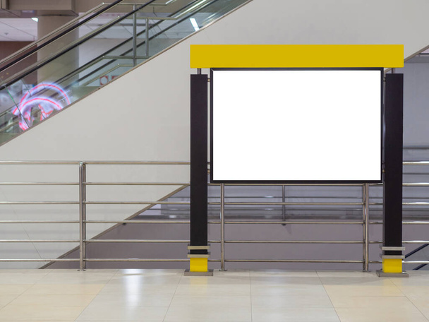 Простой белый рекламный щит черный рамка горизонтально рядом с эскалатором в терминале аэропорта для средств массовой информации, рекламы, маркетинга. Вывеска для рекламы в помещении. Пространство для текста - Фото, изображение