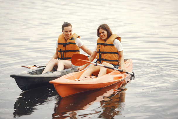 Women paddling on a lake in a kayak - 写真・画像