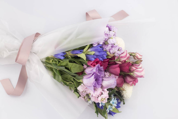 Beautiful pink, purple Lisianthus bouquet in full bloom with green leaves - Фото, изображение