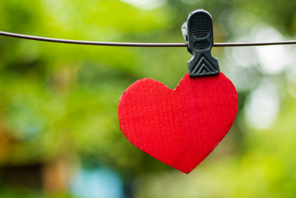 tagliere a forma di cuore rosso appeso al filo. 29 settembre giornata mondiale del cuore - Foto, immagini