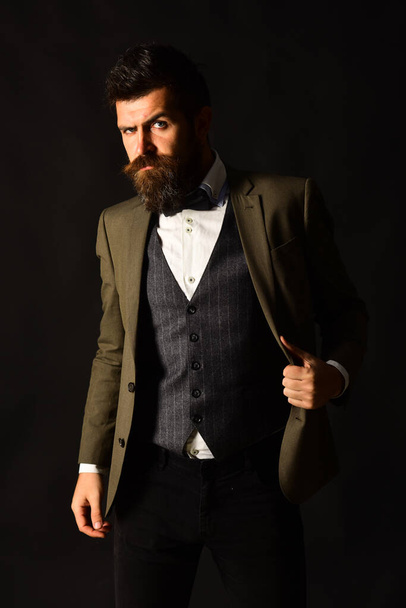 Man in retro smart suit and vest on brown background. - Фото, изображение