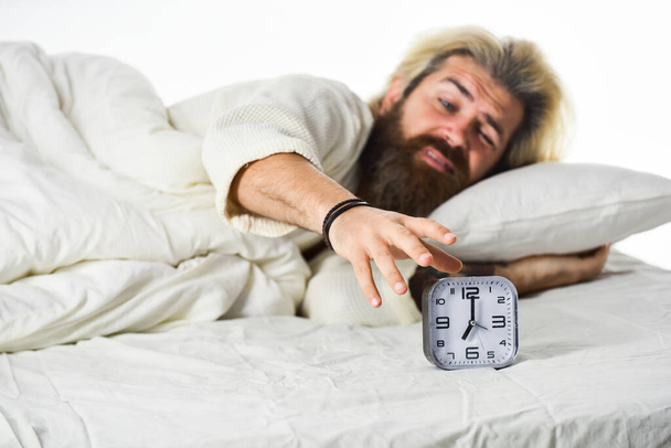 mature man turn off alarm clock. Digital alarm clock in bedroom. Time to wake up. Exhausted man being awakened by alarm clock in bedroom. Mature Man On Bed Turning Off Clock - Foto, Imagen