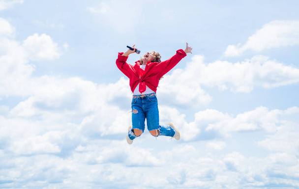 Happy kid with microphone. karaoke concept. Singing Songs. Lifestyle and People Concept. make your voice louder. teen girl singing song with microphone. having a party. jump so high - Fotó, kép