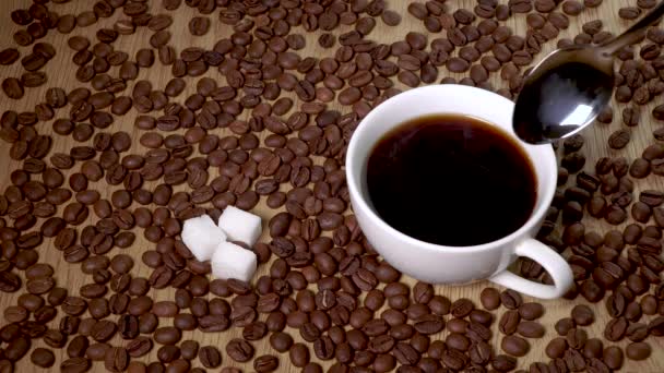 Łyżka miesza czarną kawę w filiżance - Materiał filmowy, wideo