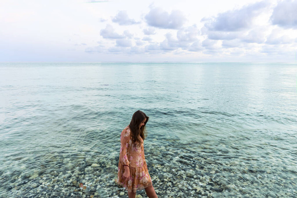 Молодая девушка вечером у моря, закат у моря - Фото, изображение