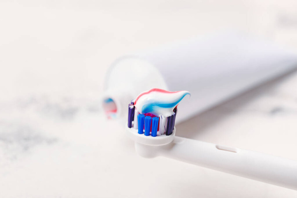 Електрична зубна щітка з пастою на столі, крупним планом
 - Фото, зображення