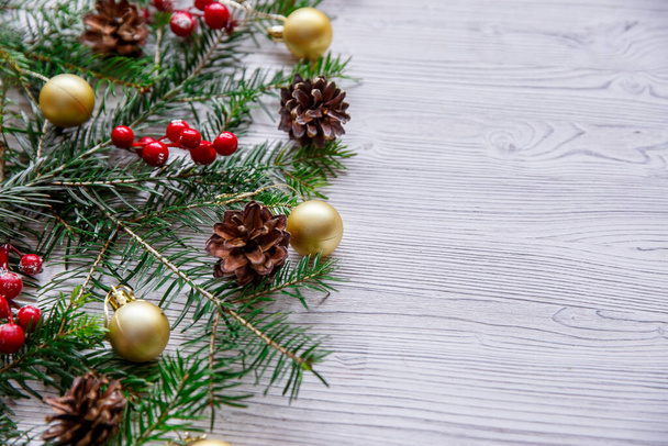 白い木の背景にクリスマスツリーと赤い果実を持つ背景。メリークリスマスグリーティングカードフレームバナー. - 写真・画像