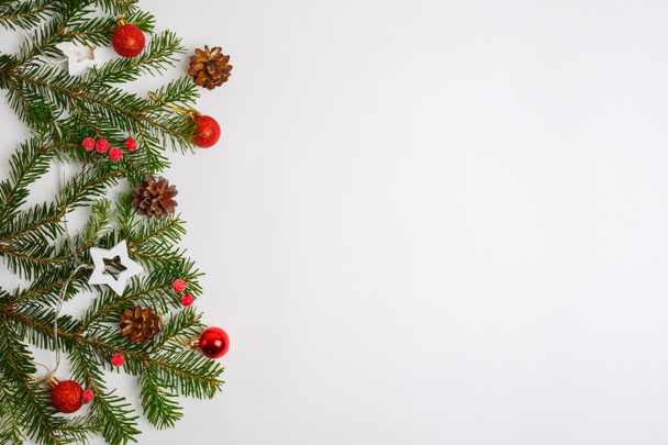 Boże Narodzenie tło, choinka gałęzie czerwony Christmas zabawki stożki, girlanda, miejsce na tekst - Zdjęcie, obraz