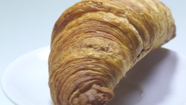 croissant leží na bílém pozadí. pečivo na izolovaném pozadí - Záběry, video