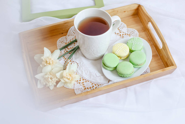 Чашка утреннего чая с макаронами и цветком - Фото, изображение